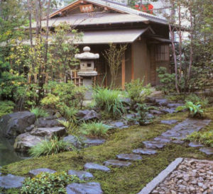 Végétaux et lanterne dansun jardin japonais avec construction traditionnelle